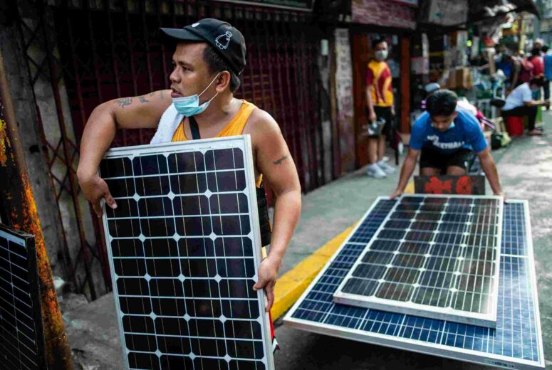 Zwei Handwerker auf den Philippinen transportieren Solarpaneele
