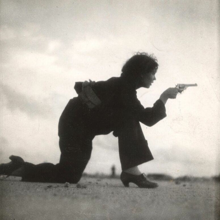Frau mit Waffe in der Pose einer Schießübung