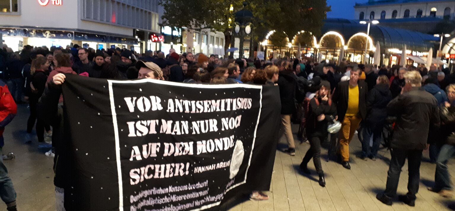 Demo mit Transpi »Vor Antisemitismus ist man nur noch auf dem Mond sicher« in Halle nach dem Anschlag - Menschen auf der Straße
