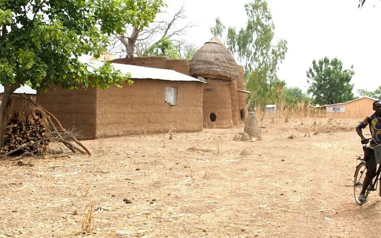 Haus mit Erntespeicher in Nadoba im Norden Togos in einer Savannenlandschaft