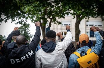 Junge Männer und frauen strecken ihre Fäuste in die Luft. Mahnwache im Gedenken an George Floyd in Freiburg, 06. Juni 2022 | Foto: Sévérine Kpoti