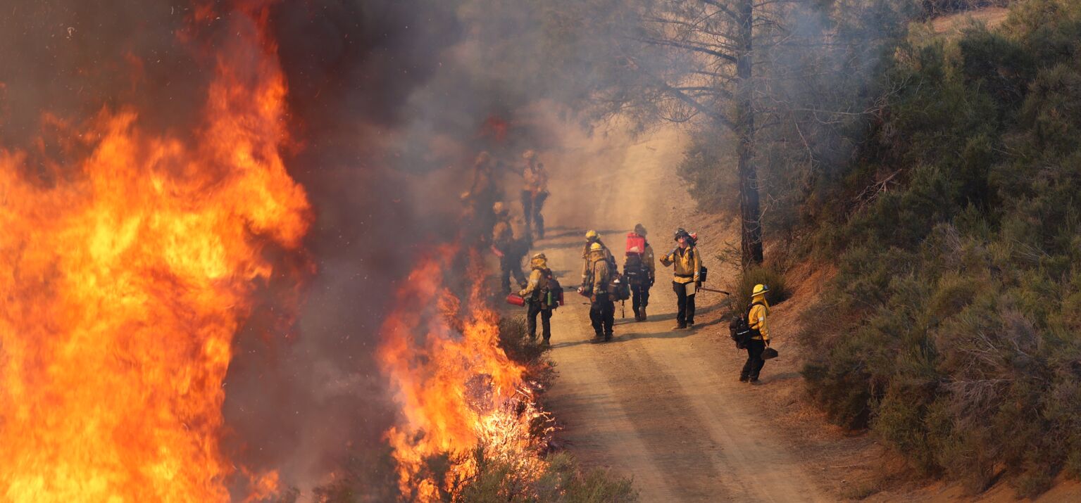 Rettungskräfte bei Löscharbeiten eines Waldbrands aufgrund der Klimaerwärmung