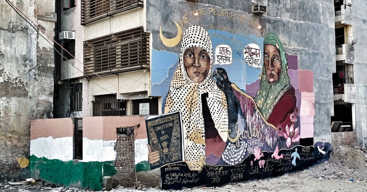 Wandbild mit Darstellung zweier weiblicher Personen und eines Falken an der Hauswand eines Wohnblocks in Shaheen Bagh.