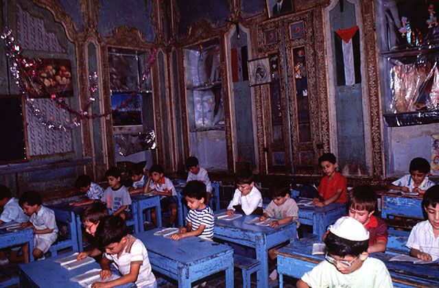 Jüdische Schüler der Maimonides-Schule im historischen Maison Lisbona in Damaskus - Die Schüler sitzen an blauen Tischen und schreiben - Das Foto wurde kurz vor dem Exodus der meisten verbliebenen syrisch-jüdischen Gemeindem im Jahr 1992 aufgenommen