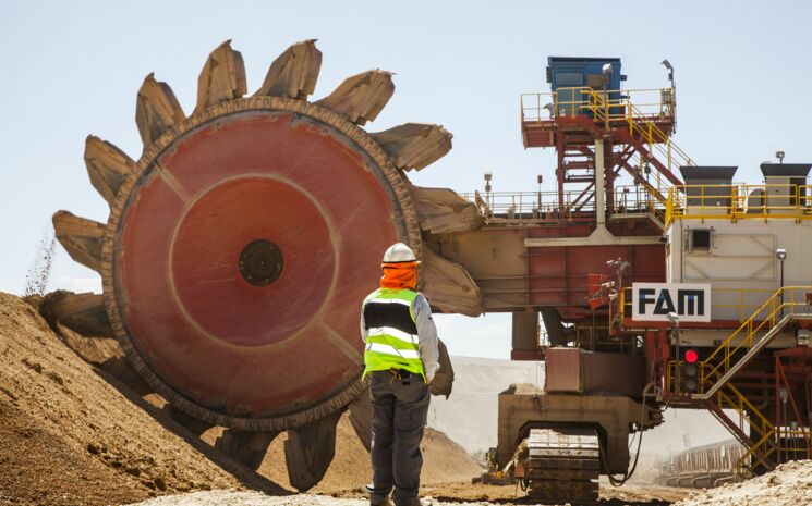 Schaufelbagger mit Arbeiter in Schutzkleidung in einer Kupfermine in Chile