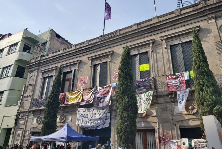 Feministische Besetzung der Nationalen Menschenrechtsbehörde in Mexiko-Stadt. Am Haus hängen Transparente mit politischen Forderungen