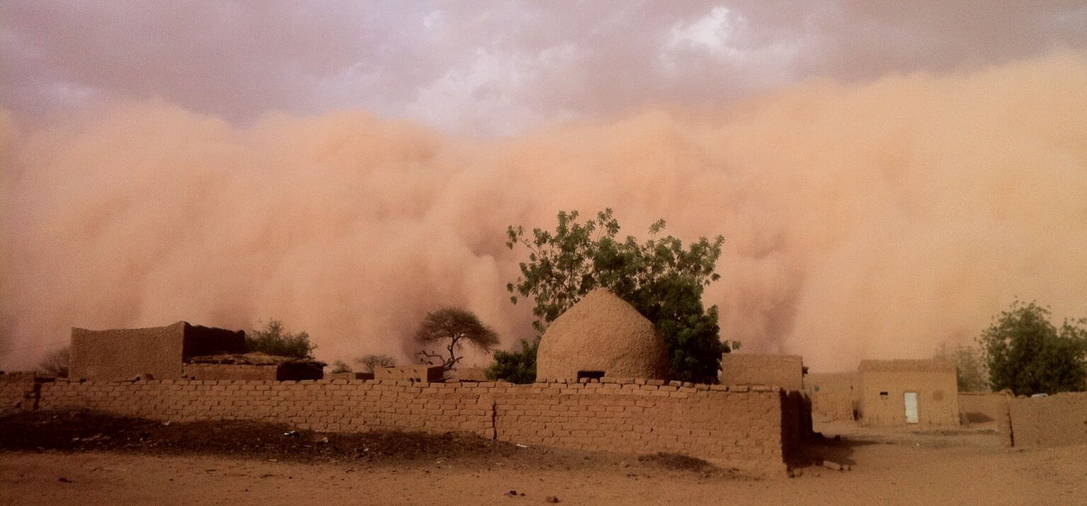 Ein Sandgewitter rollt auf ein Dorf zu