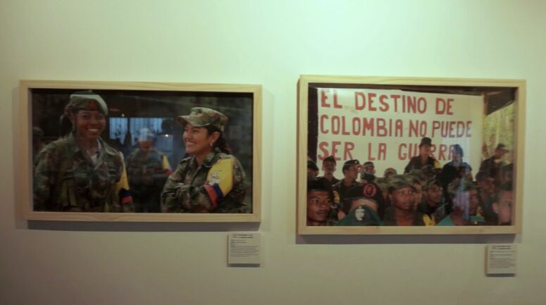 zwei Bilderrahmen mit Fotos von FARC Kämpfer*innen in einer Ausstellung in Bogotá
