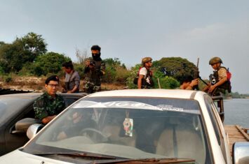 PDF-Kämpfer überqueren mit zwei Autos einen Fluss in Myanmar.