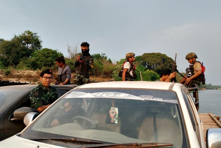 PDF-Kämpfer überqueren mit zwei Autos einen Fluss in Myanmar.