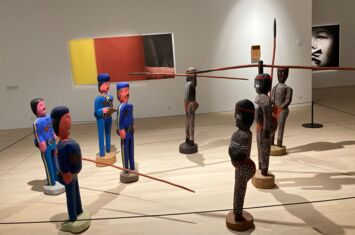 Ausstellungsobjekt bei dem sich vier Figuren links und vier Figuren rechts gegenüberstehen