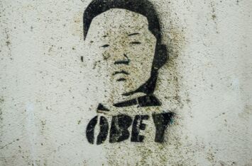 schwarzes Graffity auf heller Mauer mit der Aufschrift OBEY - steht für Autoritarismus